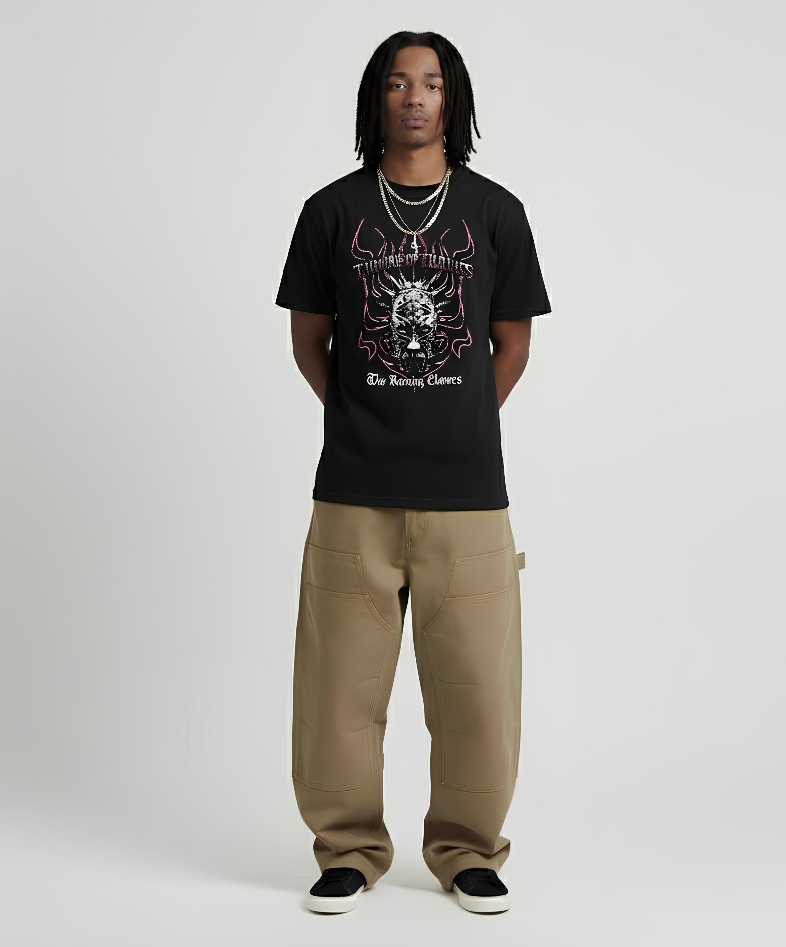 Person wearing a black t-shirt with graphic design and beige pants on a white background