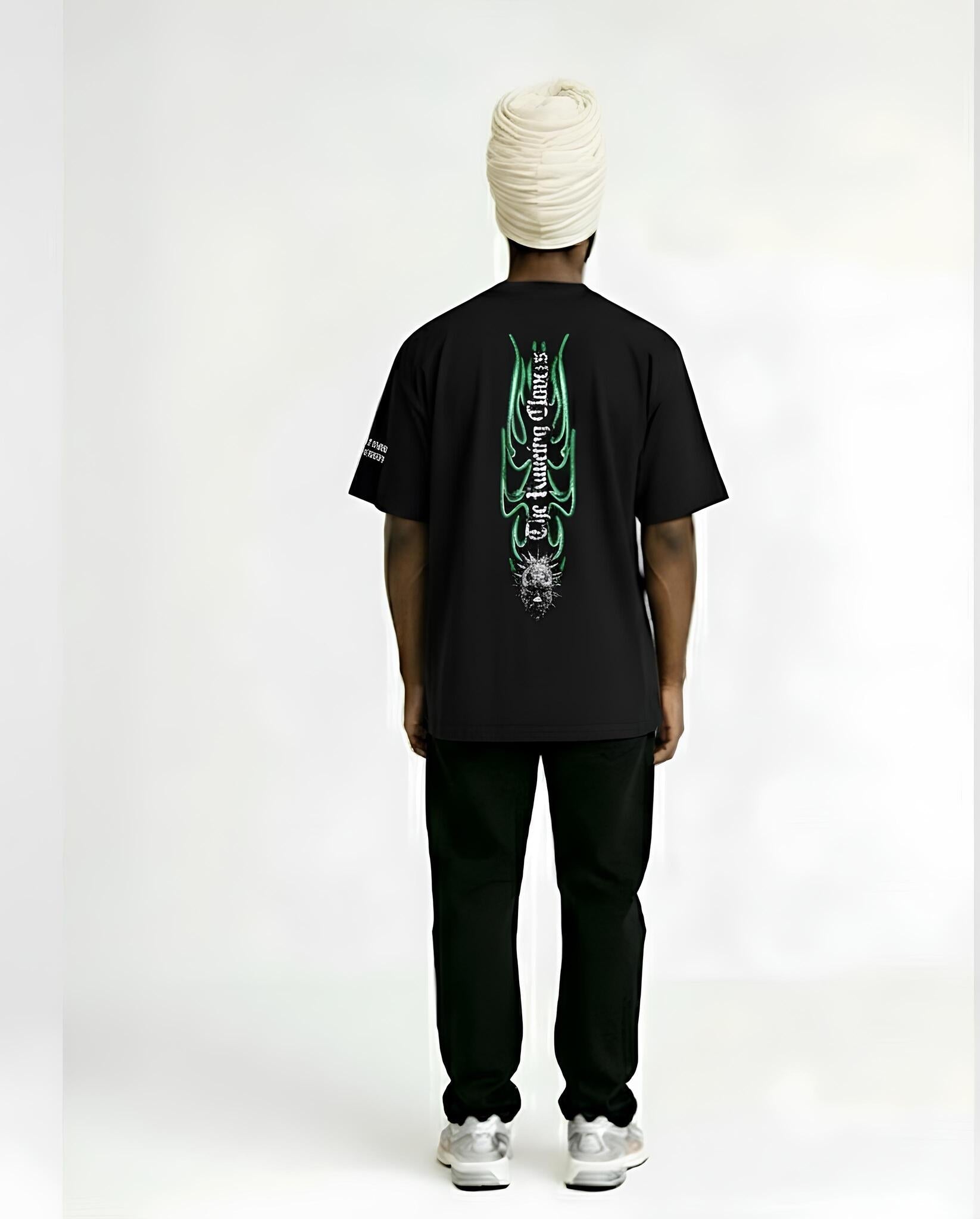Person wearing a black t-shirt with green designs on the back, standing against a white background