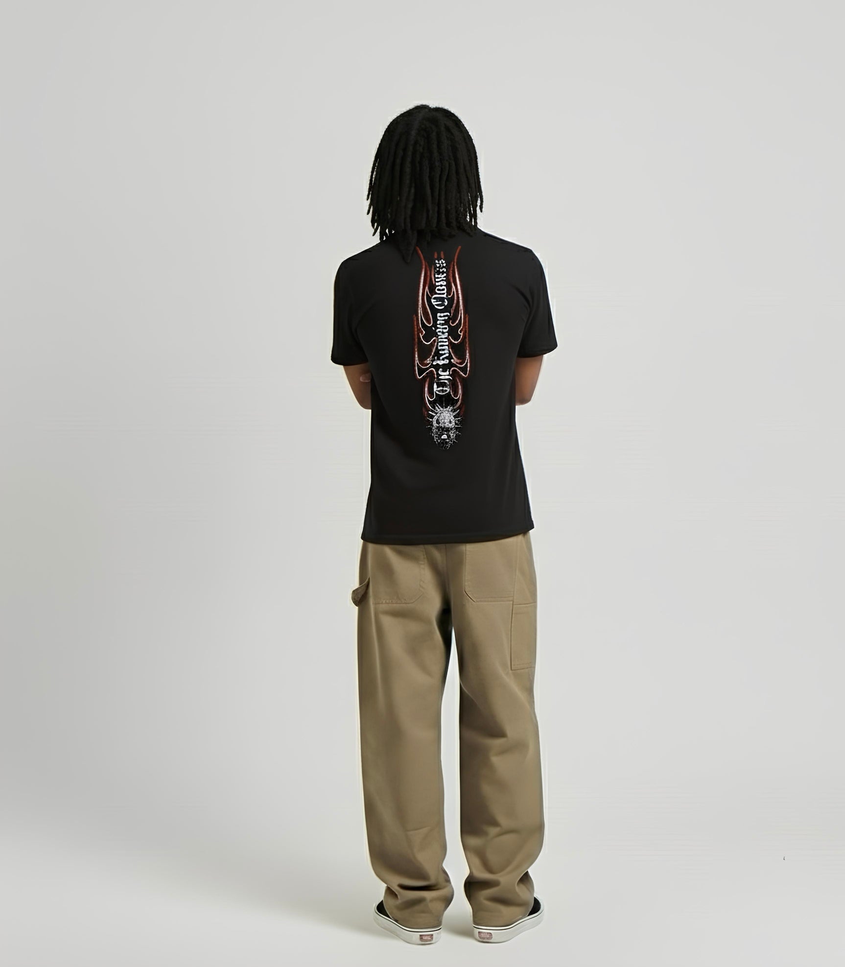 Person wearing a black t-shirt with a graphic design on the back, standing against a plain background.