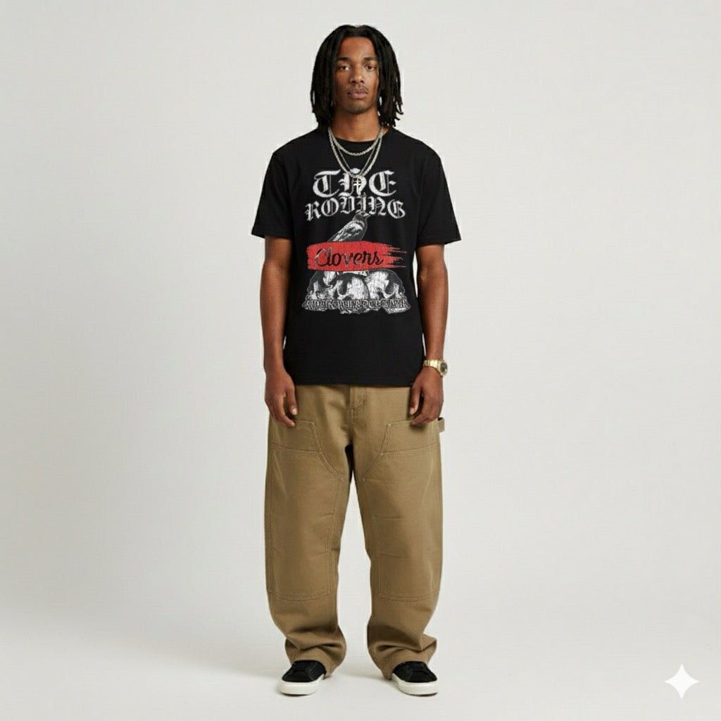 Person wearing a black t-shirt with graphic design and text, standing against a plain background