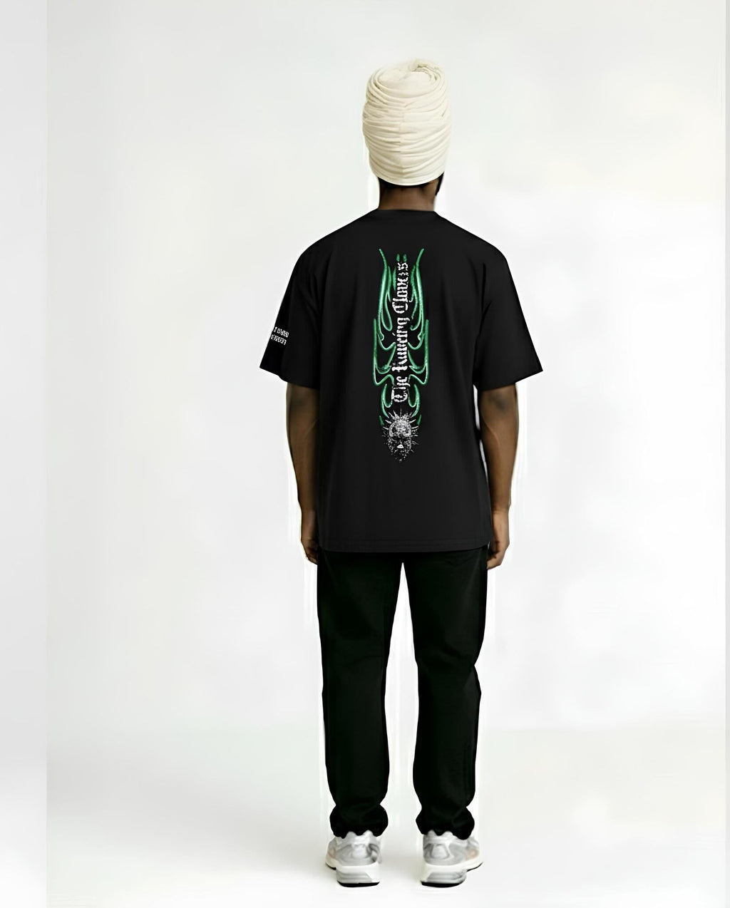 Person wearing a black t-shirt with green designs on the back, standing against a white background
