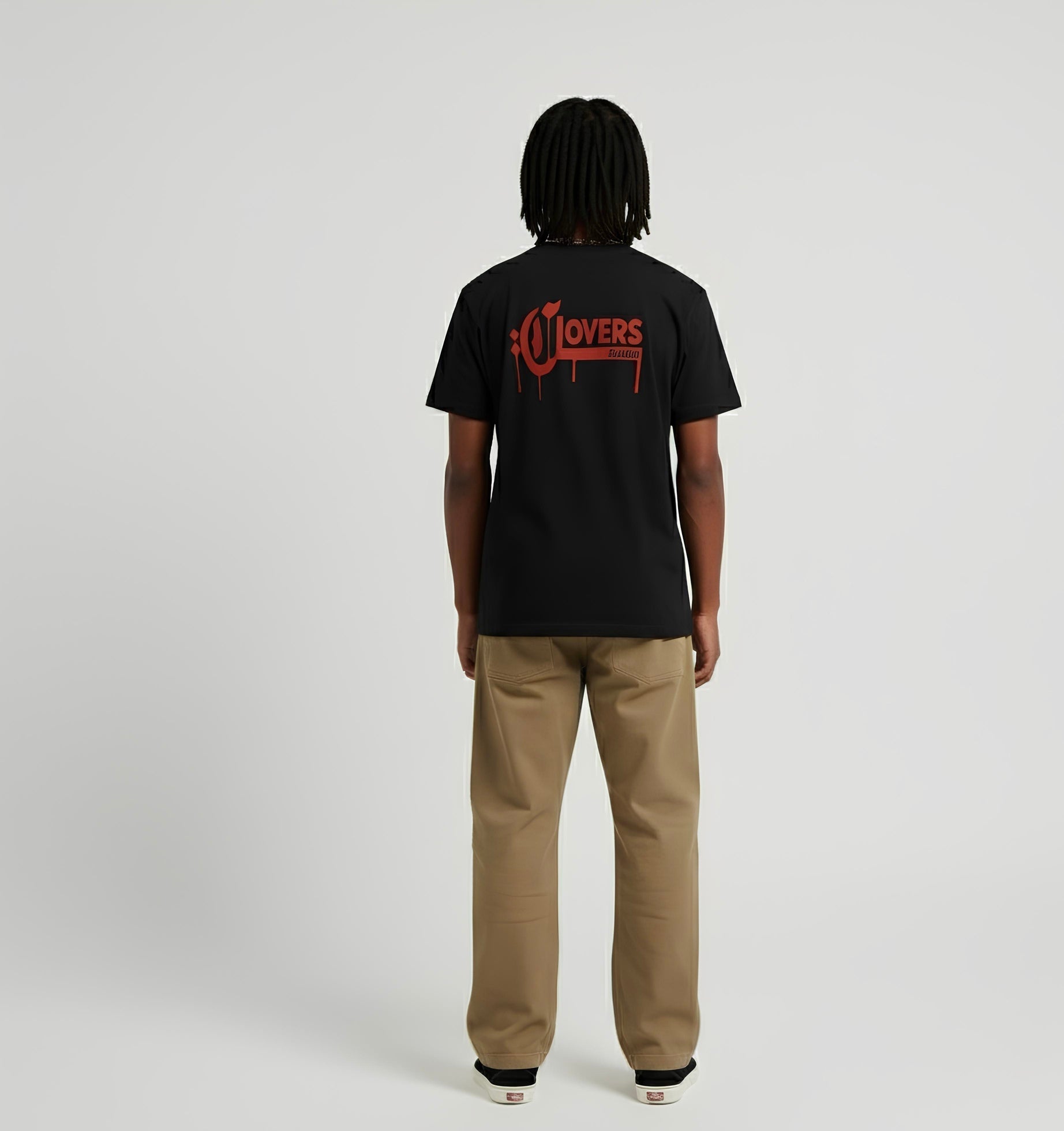 Person wearing a black t-shirt with a red logo on the back, standing against a plain background