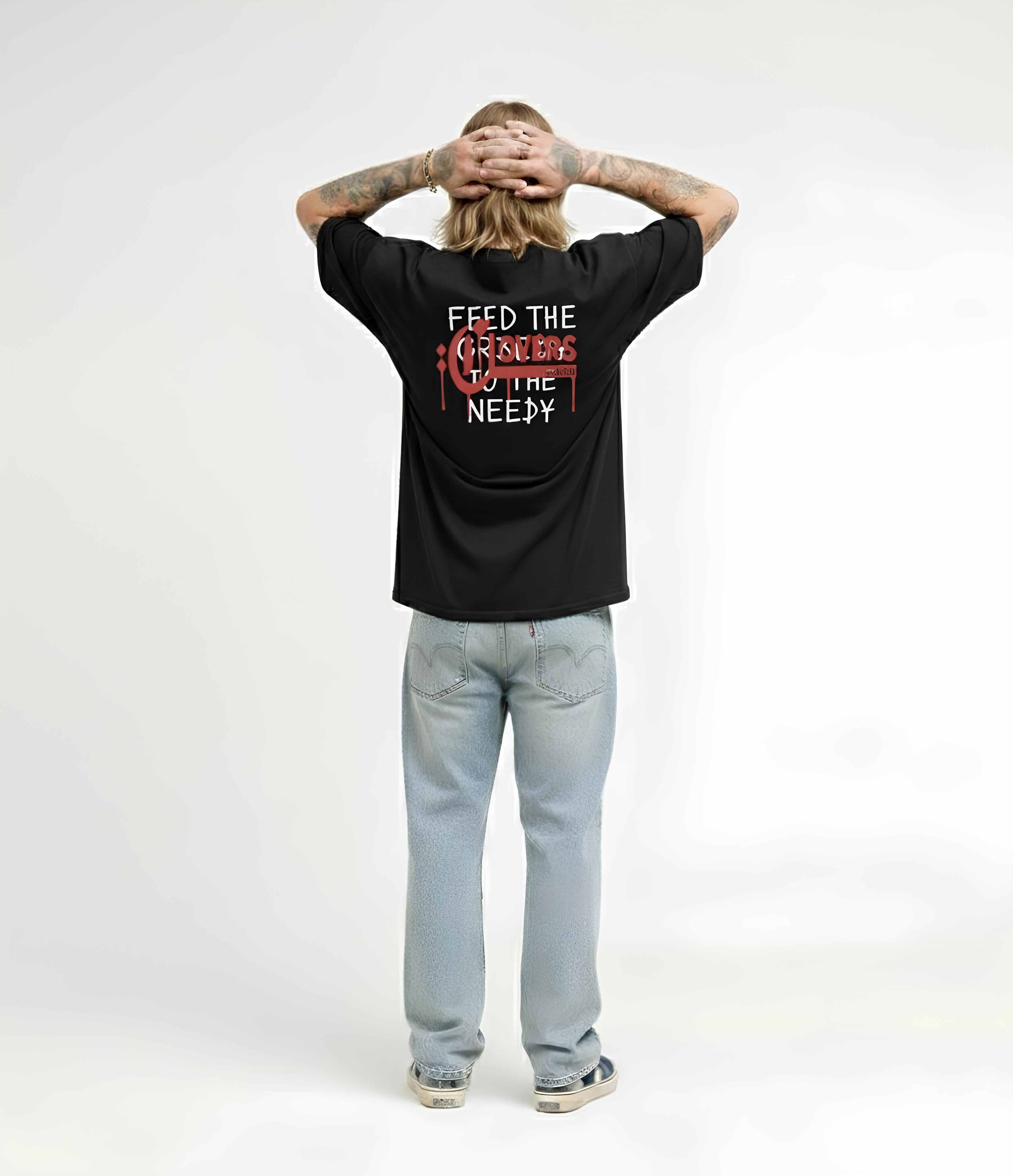 Person wearing a black t-shirt with text and graphics, standing against a white background