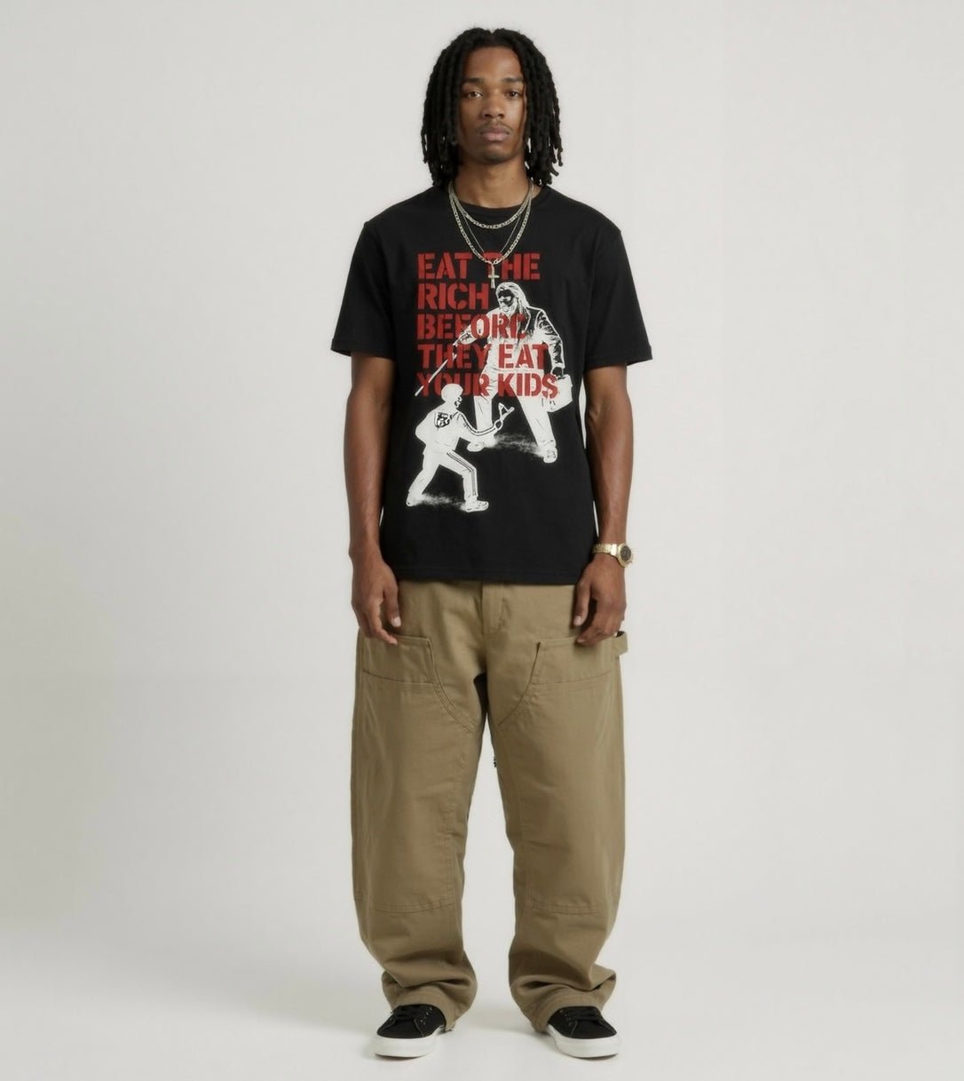 Person wearing a black t-shirt with graphic design and text, standing against a plain background