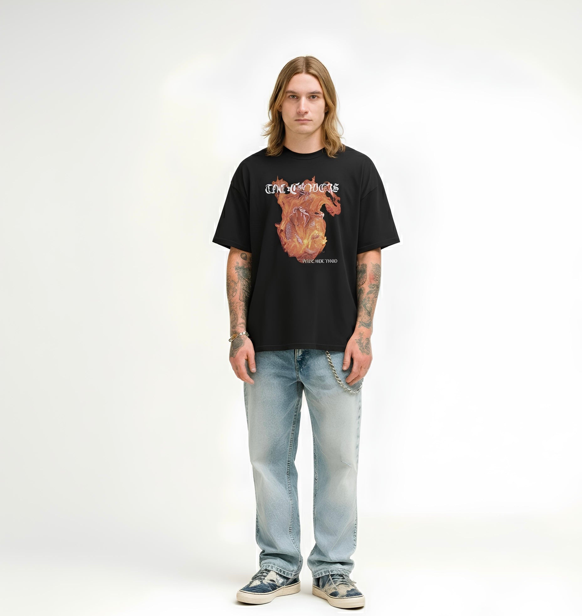 Person wearing a black t-shirt with a graphic design and light blue jeans on a white background