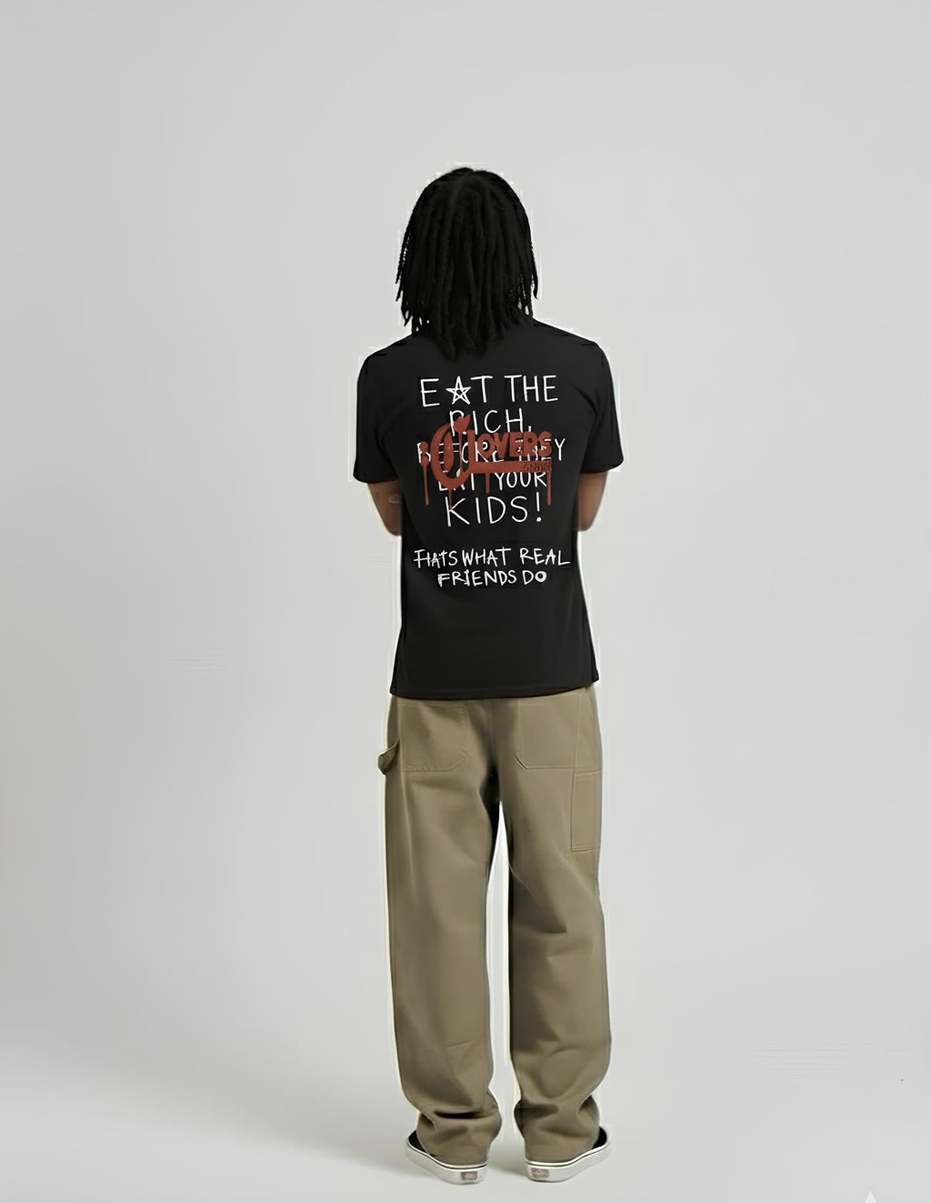 Person wearing a black t-shirt with text on the back, standing against a plain background