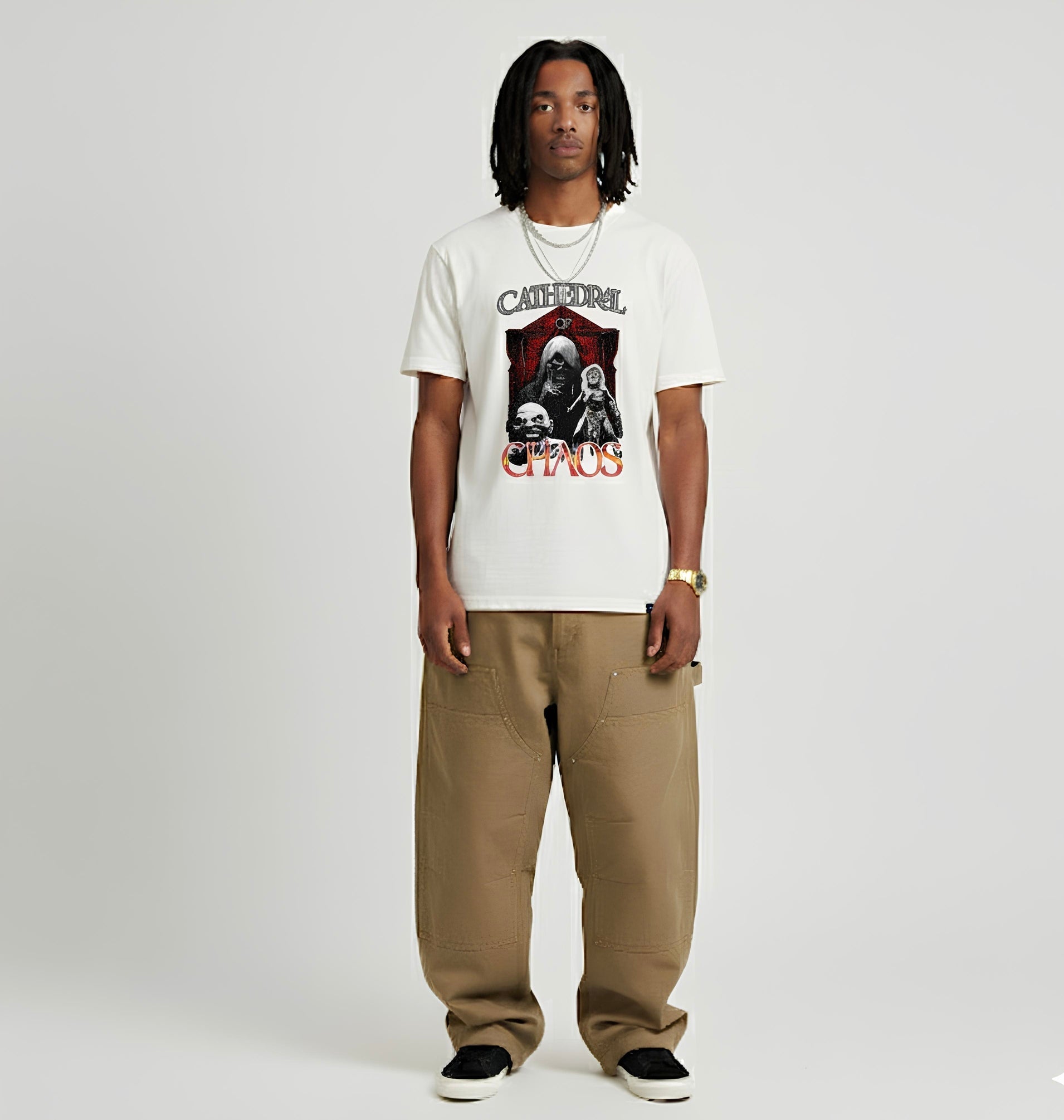 Person wearing a white t-shirt with graphic design and text, standing against a plain background