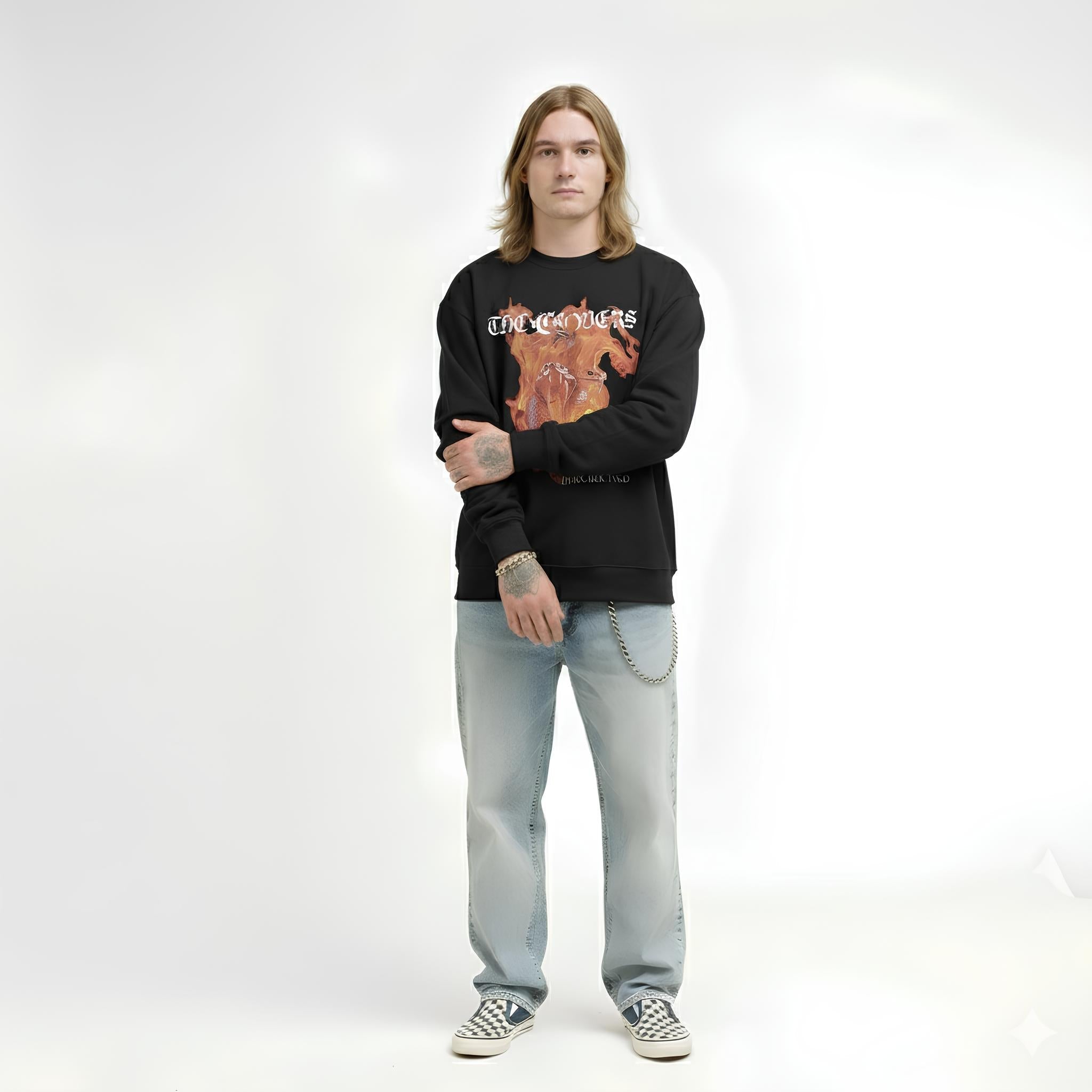 Person wearing a black sweatshirt with graphic design and light blue jeans on a white background